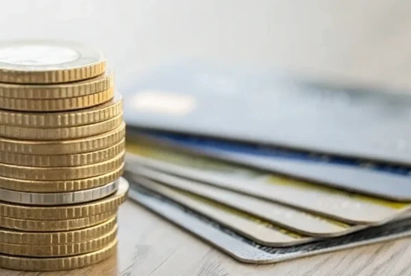 A stack of cash next to credit cards, an option from the best merchant services with a cash discount program.